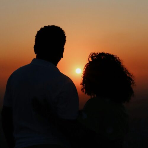 a married couple looking at a sunset
