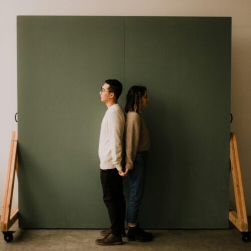 philadelphia Couple standing back to back while holding hands, showing connection despite differences in couples sex therapy