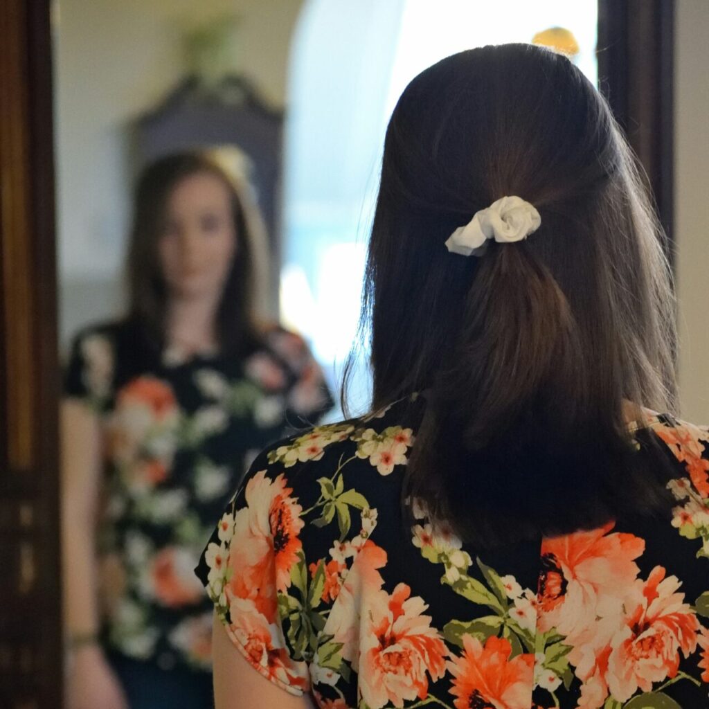 a woman looking in the mirror thinking about her low self-esteem