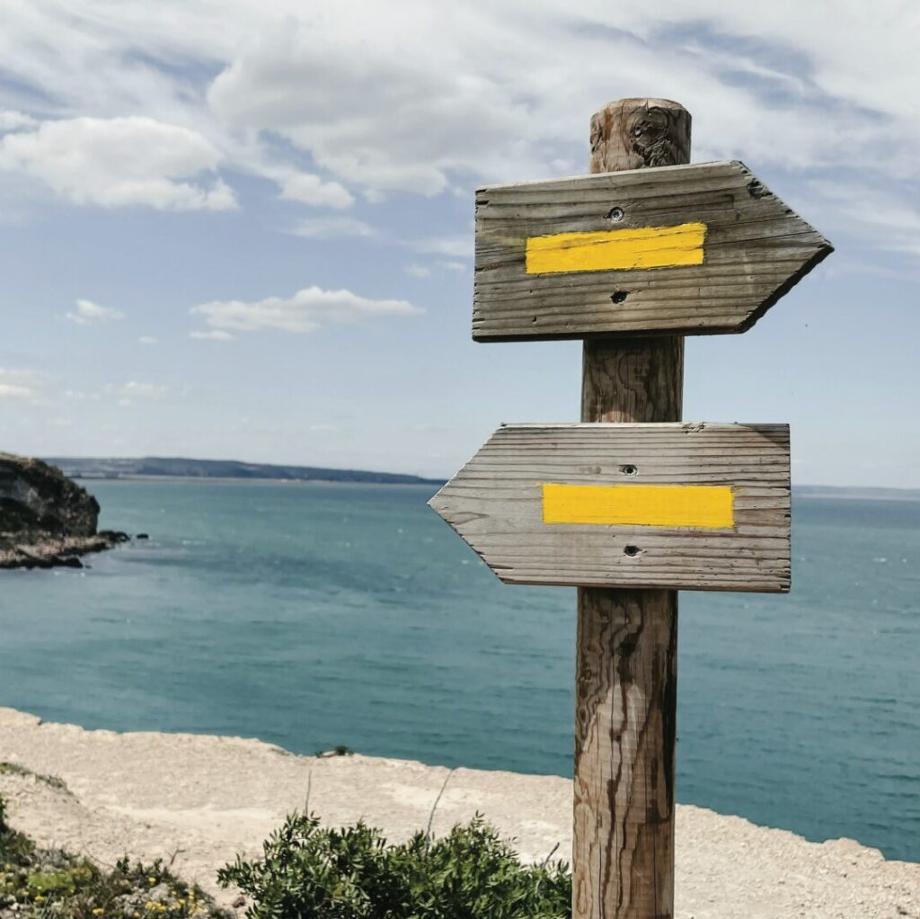 two signs that say one way or another symbolizing the decision between a therapist or a psychiatrist