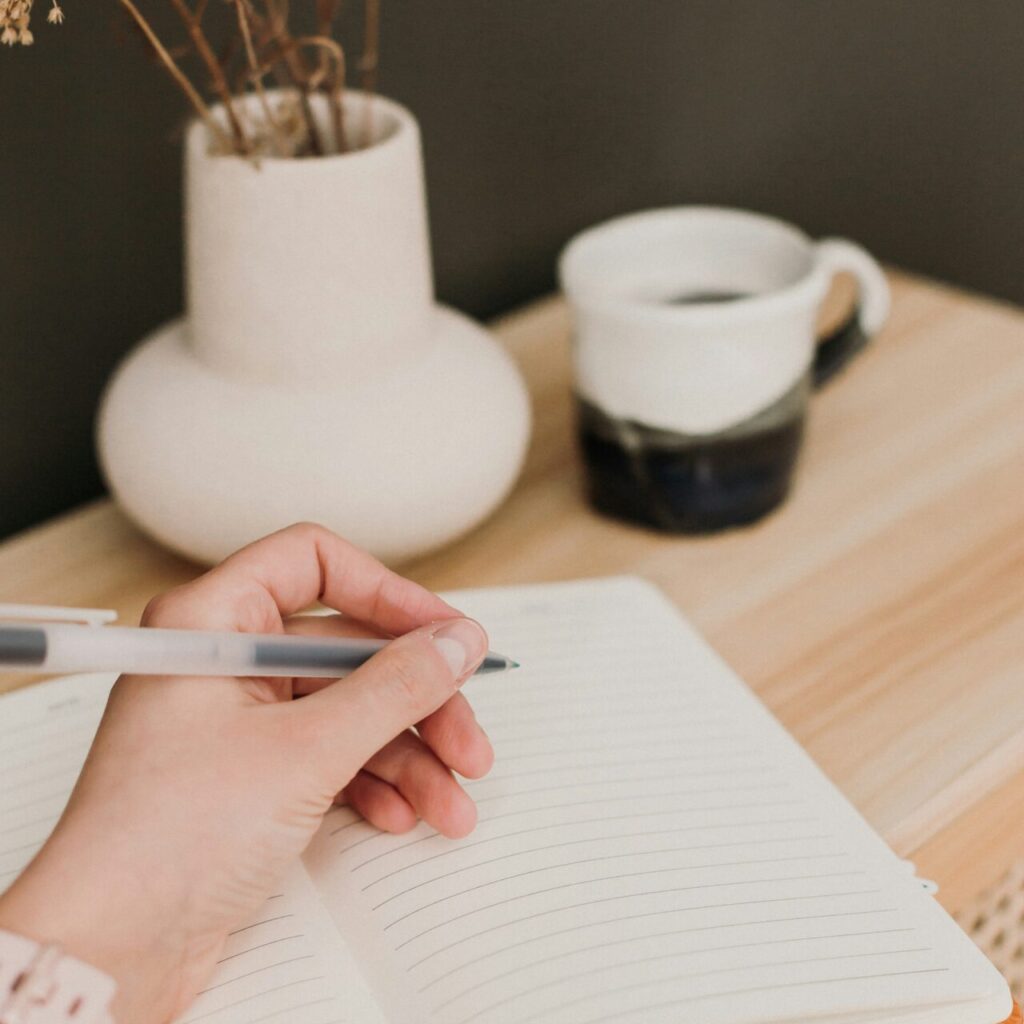 a woman writing in a notebook symbolizing cbt therapy for depression